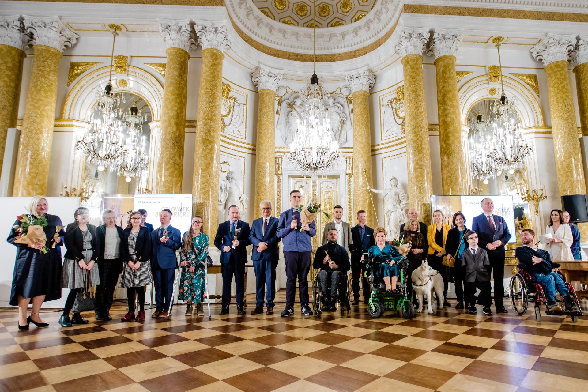 zdjęcie grupowe laureatów i finalistów konkursu Człowiek bez barier we wnętrzach Zamku Królewskiego